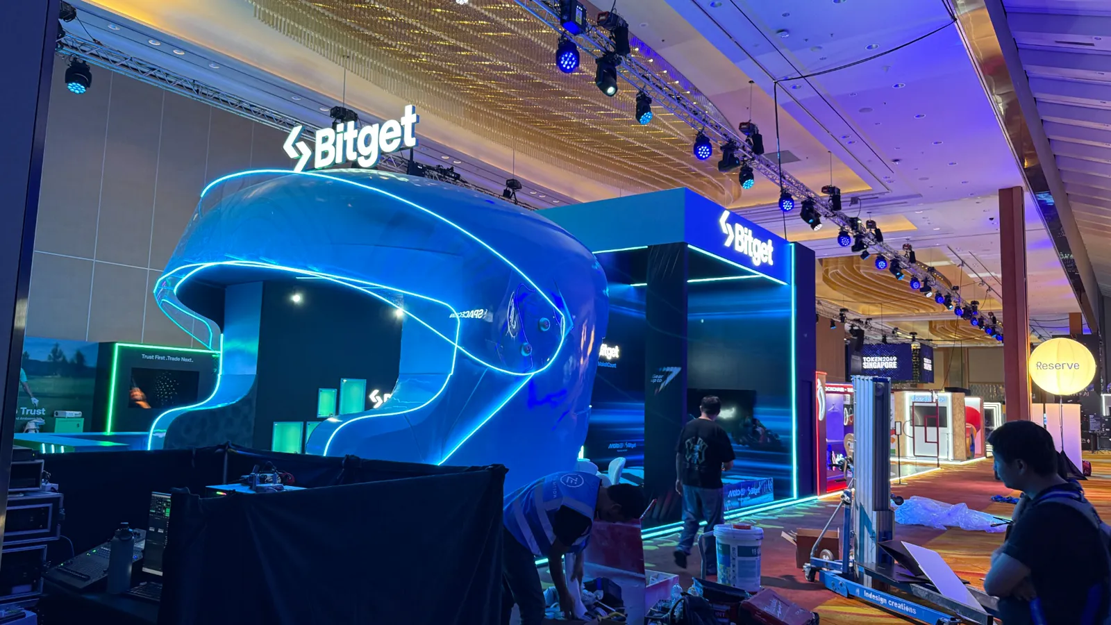 Exhibition booth contractor completing a custom illuminated trade show stand before opening