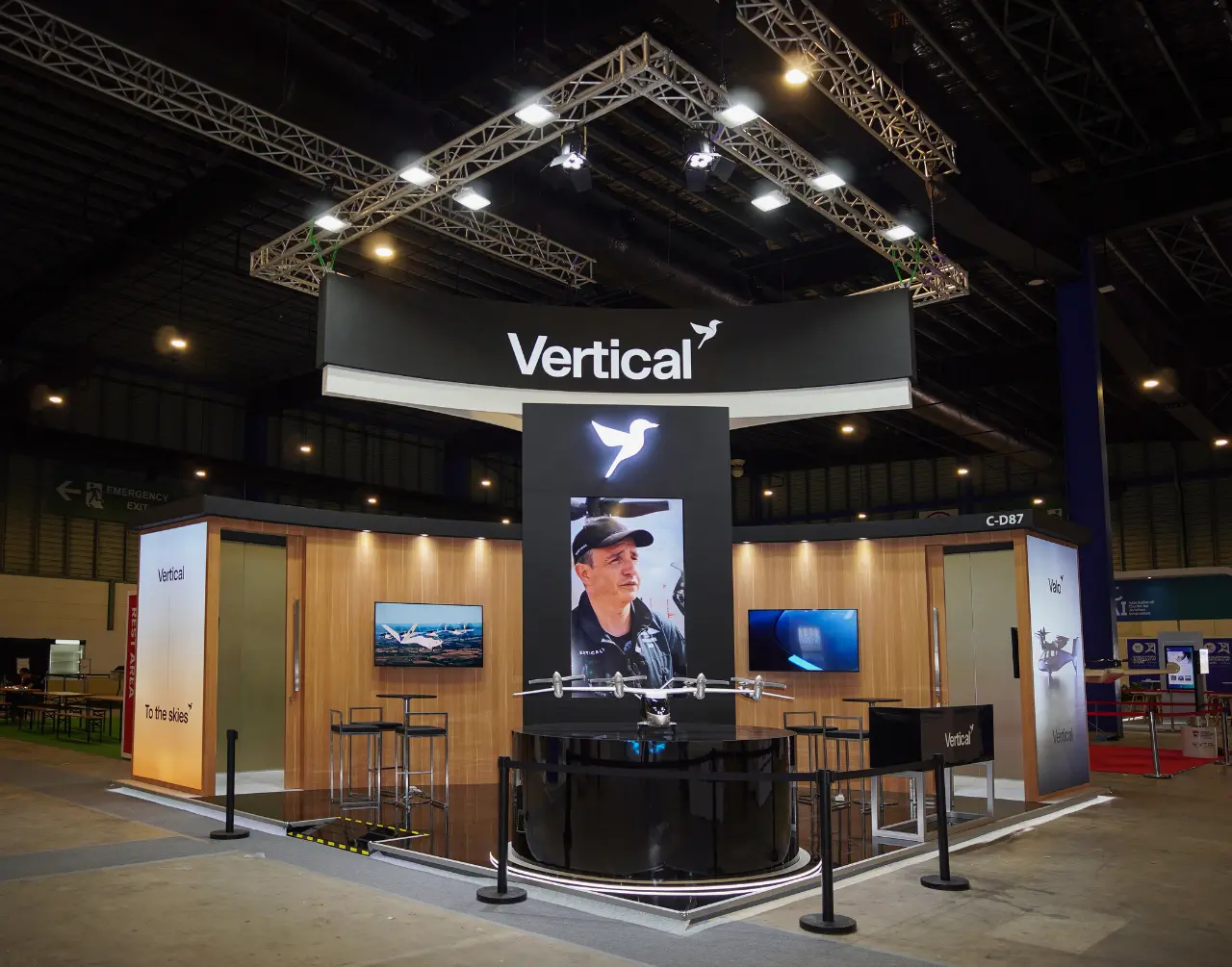 Dark, symmetrical Vertical aerospace stand with a suspended canopy and central aircraft display